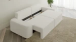 Das Sofa OVAL im Stoff Anthology 1 mit geöffnetem Bettkasten, der großzügigen Stauraum für Kissen und Decken bietet.