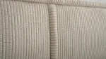 Nahaufnahme der hochwertigen Polsterung, welche die feine Textur und den eleganten Farbton des Stoffes Poso 02 im Detail präsentiert.