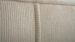 Nahaufnahme der hochwertigen Polsterung, welche die feine Textur und den eleganten Farbton des Stoffes Poso 02 im Detail präsentiert.