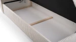 Das Bett mit hochgeklapptem Lattenrost, das einen geräumigen Bettkasten für praktischen Stauraum zeigt.