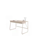 Schräge Ansicht des stilvollen Schreibtischs in Beige mit Lampe und Arbeitsutensilien auf der Tischplatte, freigestellt auf weißem Hintergrund.