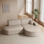 Das gemütliche Ecksofa Prima Pro im beigen Cordstoff Poso 02, stilvoll arrangiert in einem hellen, modernen Wohnzimmer.