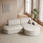 Das moderne Ecksofa Prima Pro im cremefarbenen Cordstoff Poso 100, elegant arrangiert in einem lichtdurchfluteten Wohnzimmer.