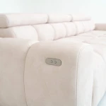 Nahaufnahme der eleganten, seitlich integrierten Bedienknöpfe für die elektrische Relaxfunktion am modernen Ecksofa Aldo in Beige.