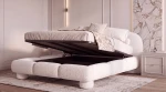 Das Polsterbett Dayton im hellen Bouclé-Stoff Quelle 01 mit hochgeklapptem Lattenrost und offenem Bettkasten in einem modernen Schlafzimmer.