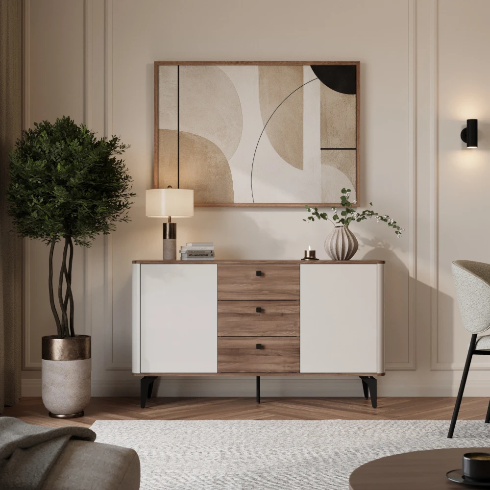 Modernes Sideboard ELENA (140 cm) mit zwei weißen Türen, drei Schubladen in warmer Holzoptik und schwarzen Metallbeinen in einem stilvollen Wohnzimmer unter einem Wandbild.