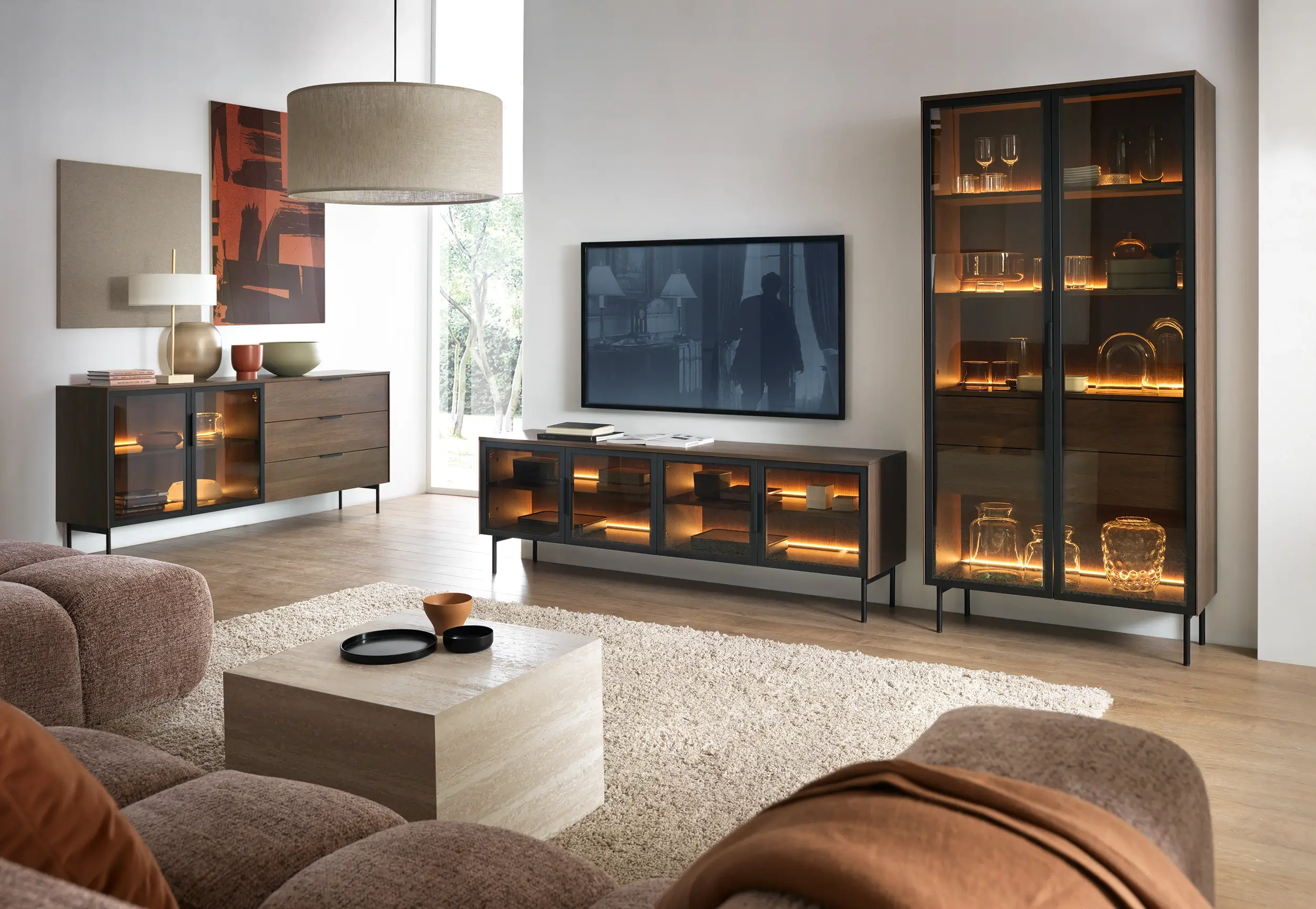 Ein modernes Wohnzimmer-Set aus dunklem Holz mit schwarzen Metallbeinen und Glastüren